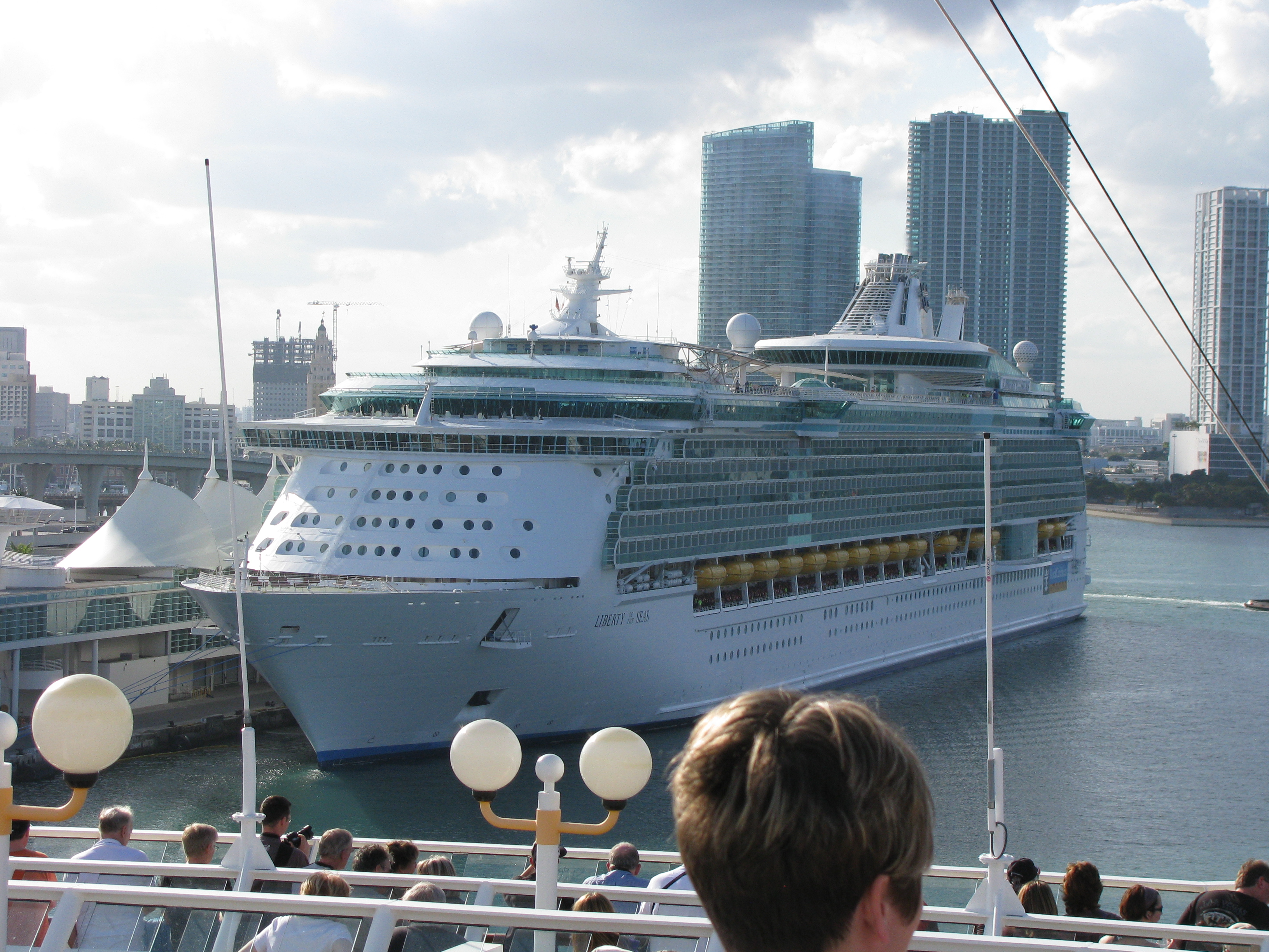 Large cruise ships docked at PortMiami with the Miami skyline in the background.