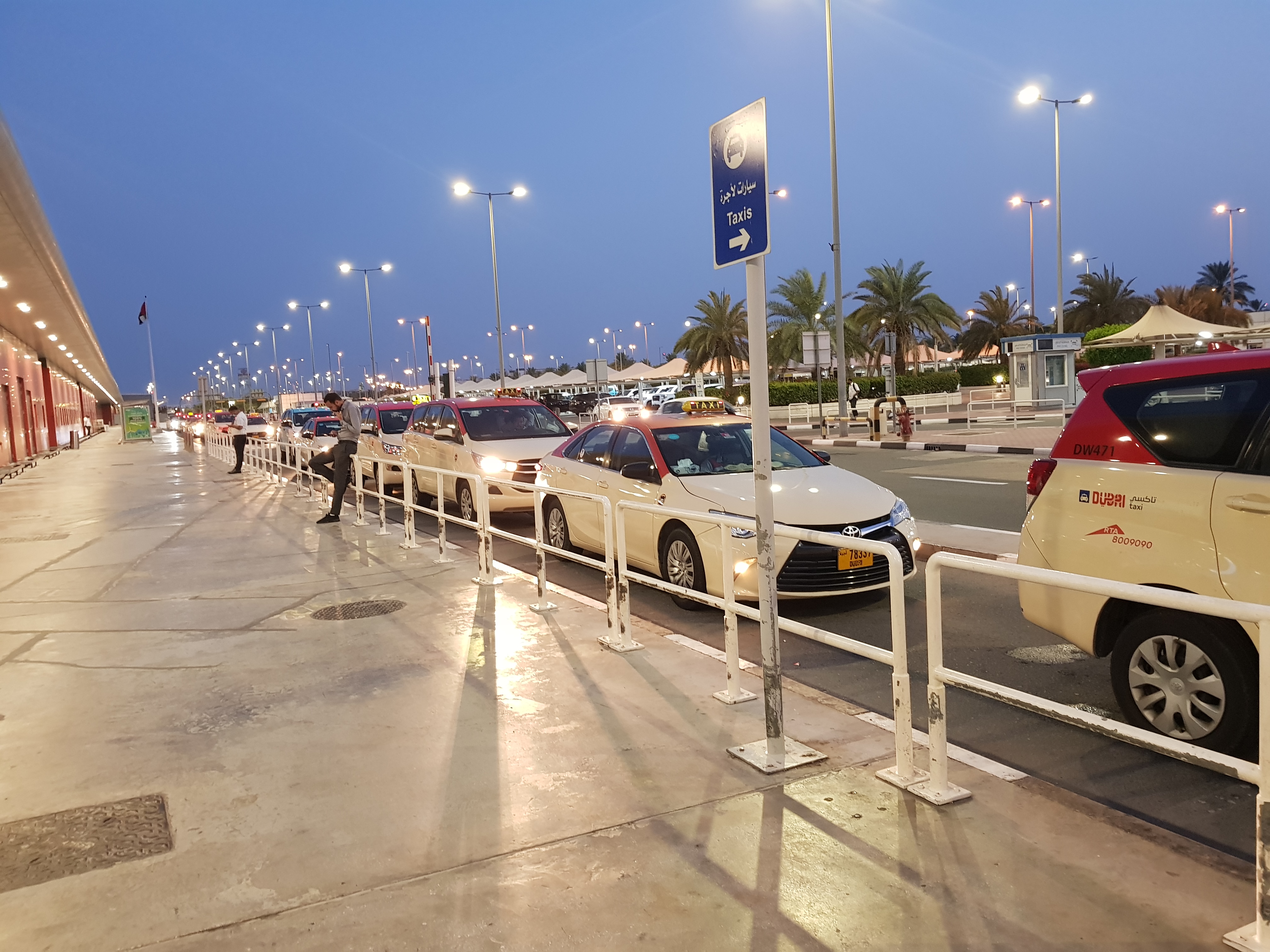 Passengers walking through a bright, modern departures concourse at Dubai International Airport.
