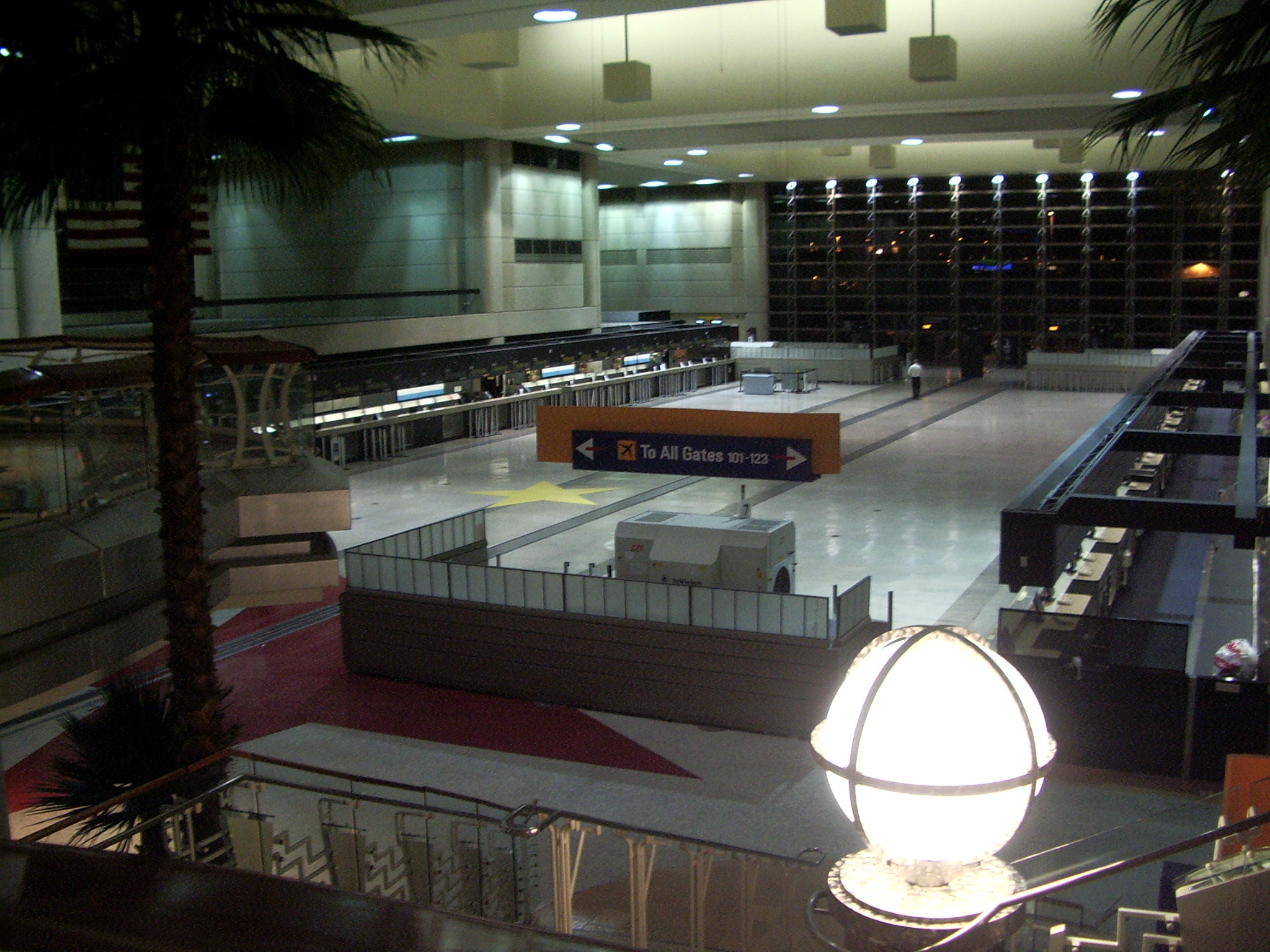 Travelers walking with rolling suitcases through a busy terminal concourse at Los Angeles International Airport.