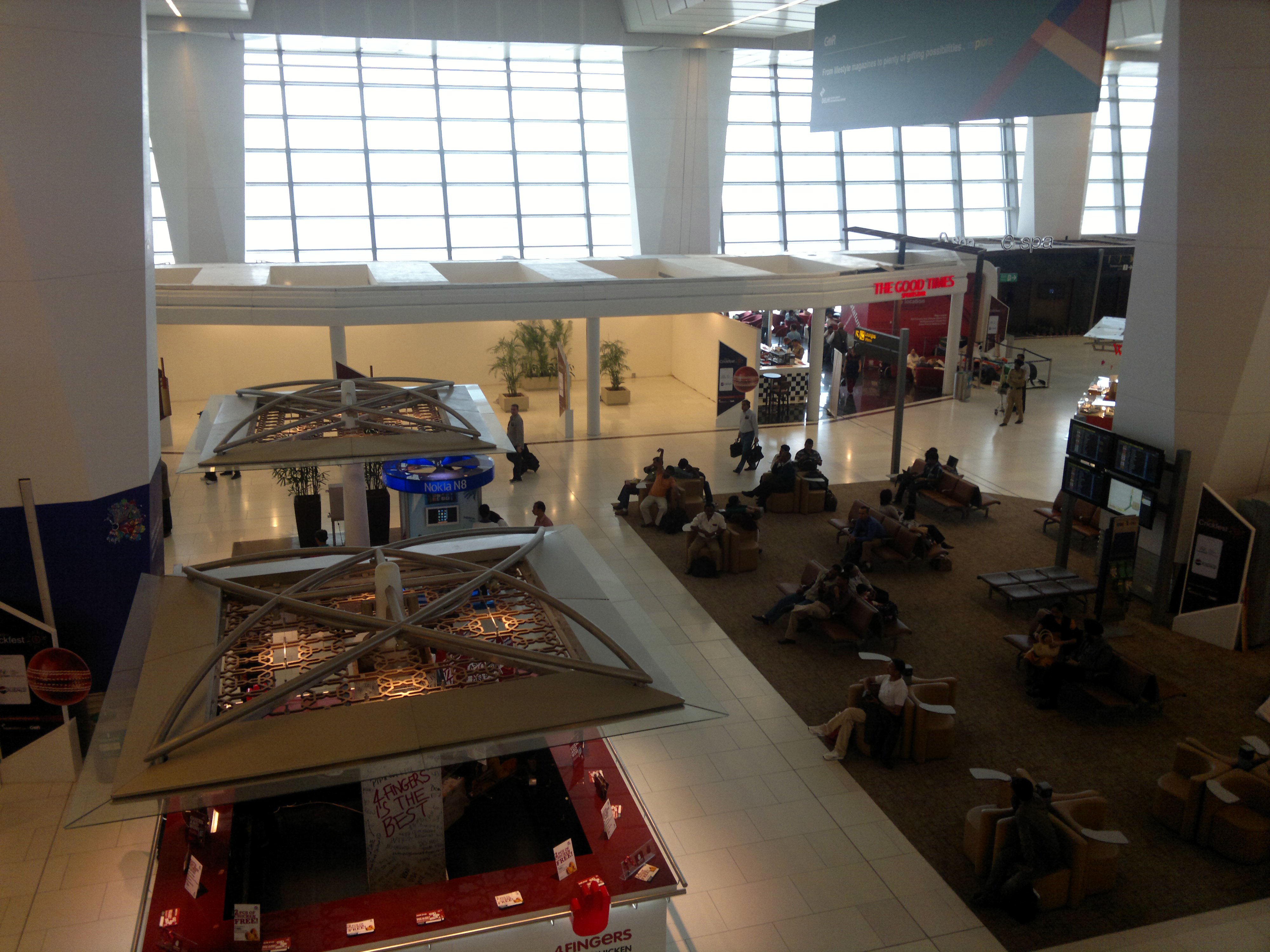 Travelers waiting in line at an immigration counter in an Indian international airport terminal.