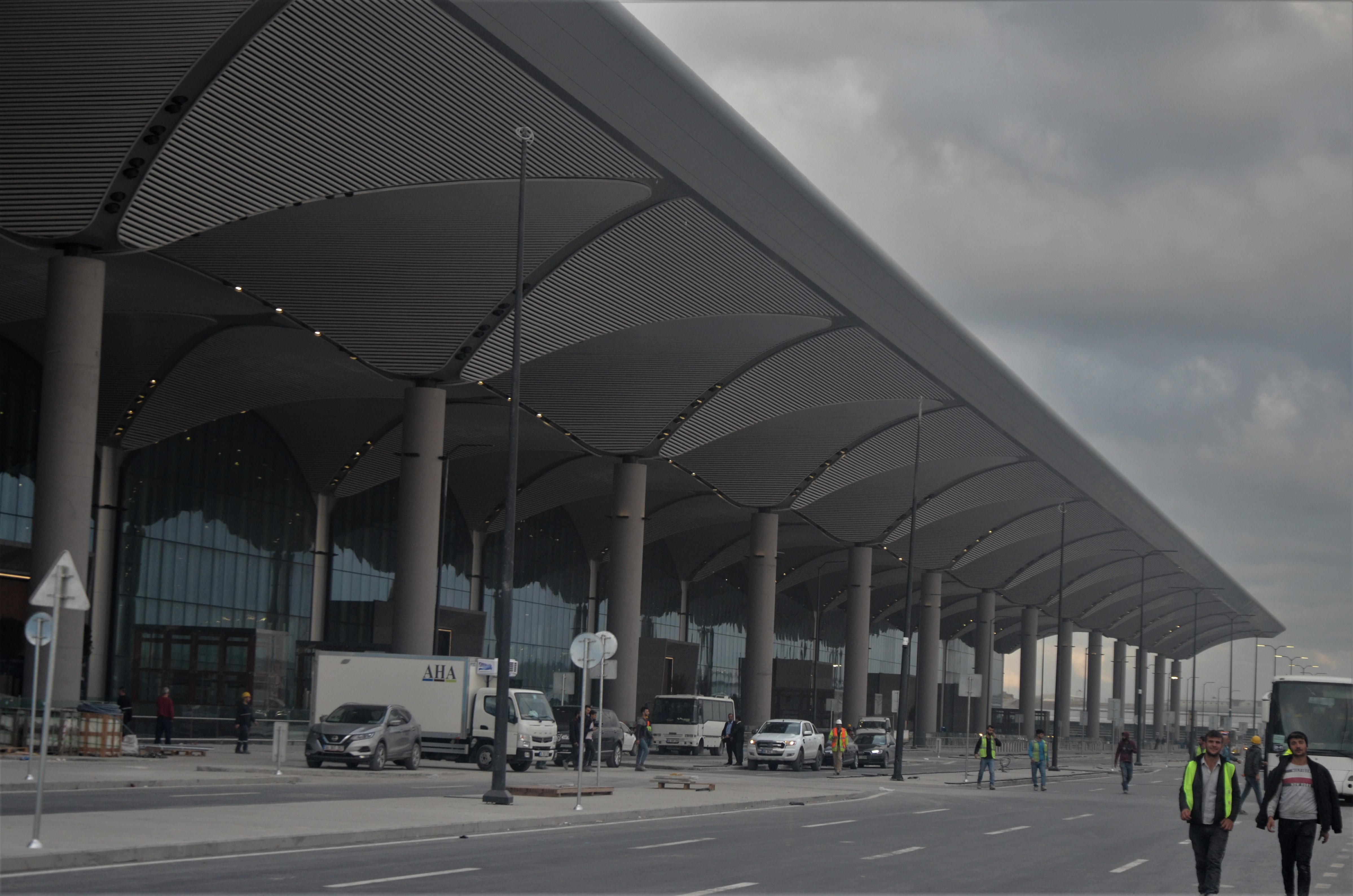 Travelers walking through the bright, high-ceilinged departures hall at Istanbul Airport.